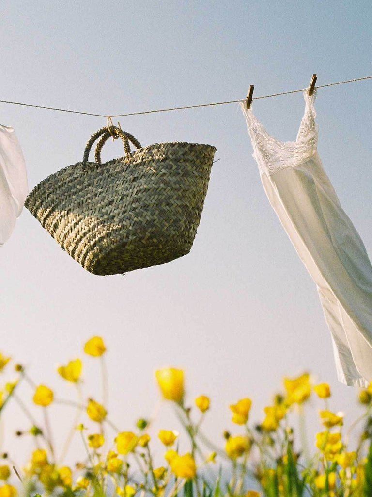 Natural woven basket with laundry hanging on a line