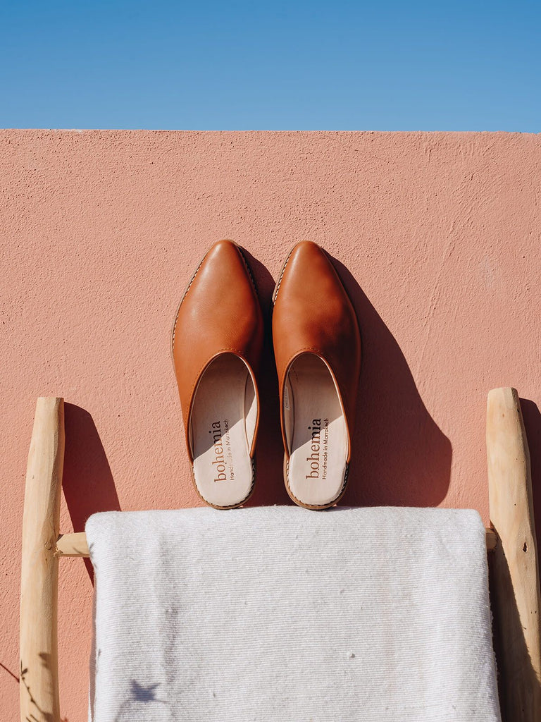 Bohemia design leather mules tan against terracotta wall and blue sky