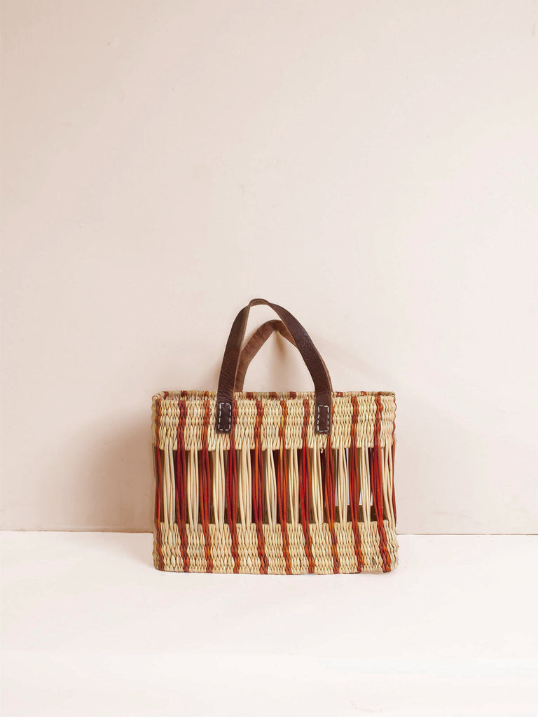 Decorative natural reed basket with short leather handles and amber stripe design