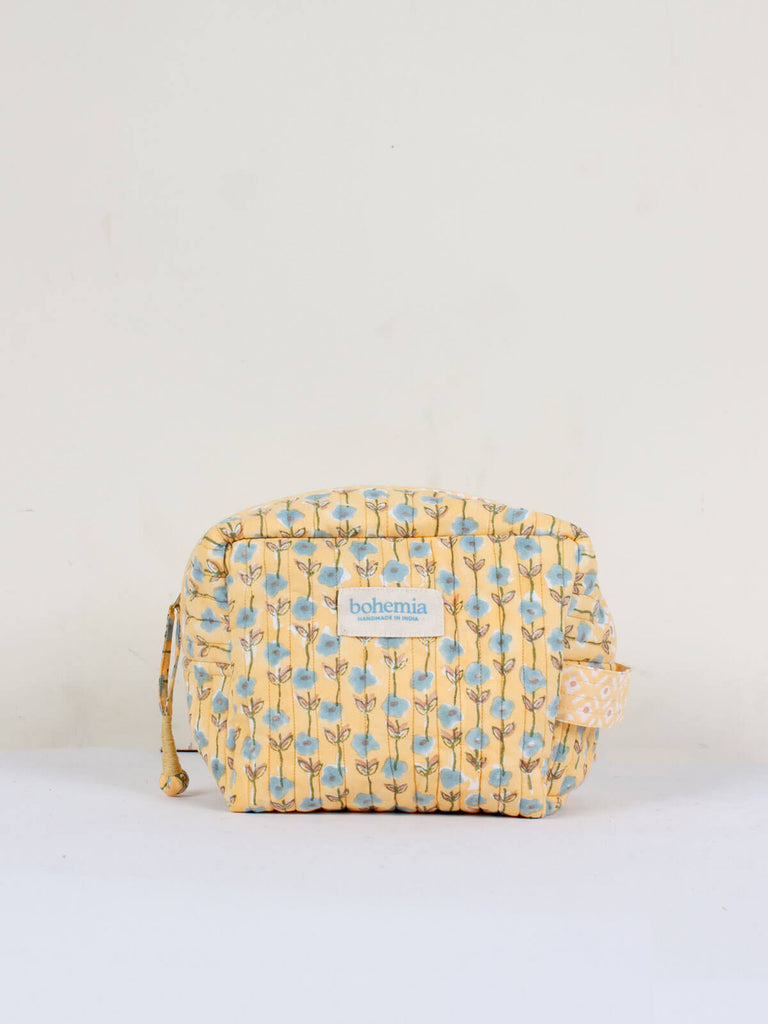 Small hand block print, cotton quilted wash bags with a creamy buttermilk yellow and blue ditsy floral pattern