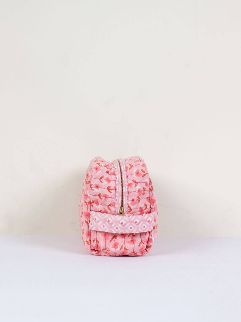 Side view showing carry handle of a quilted pink floral block print wash bag