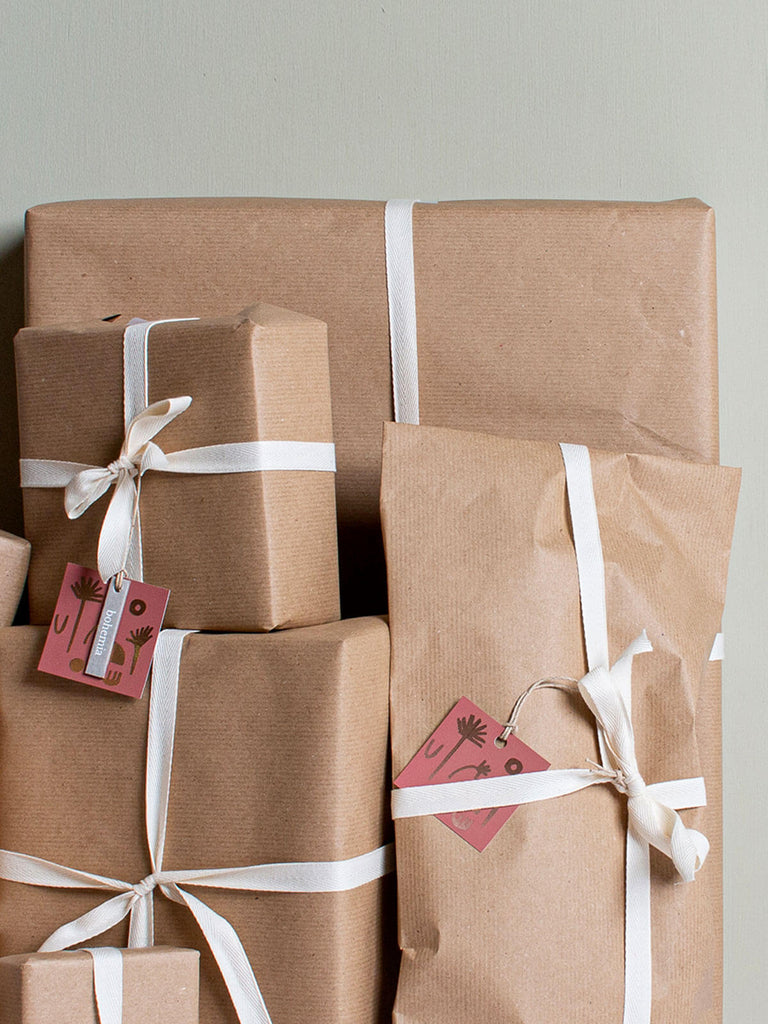 Gift wrapped parcels using brown paper, cotton tape and terracotta gift cards