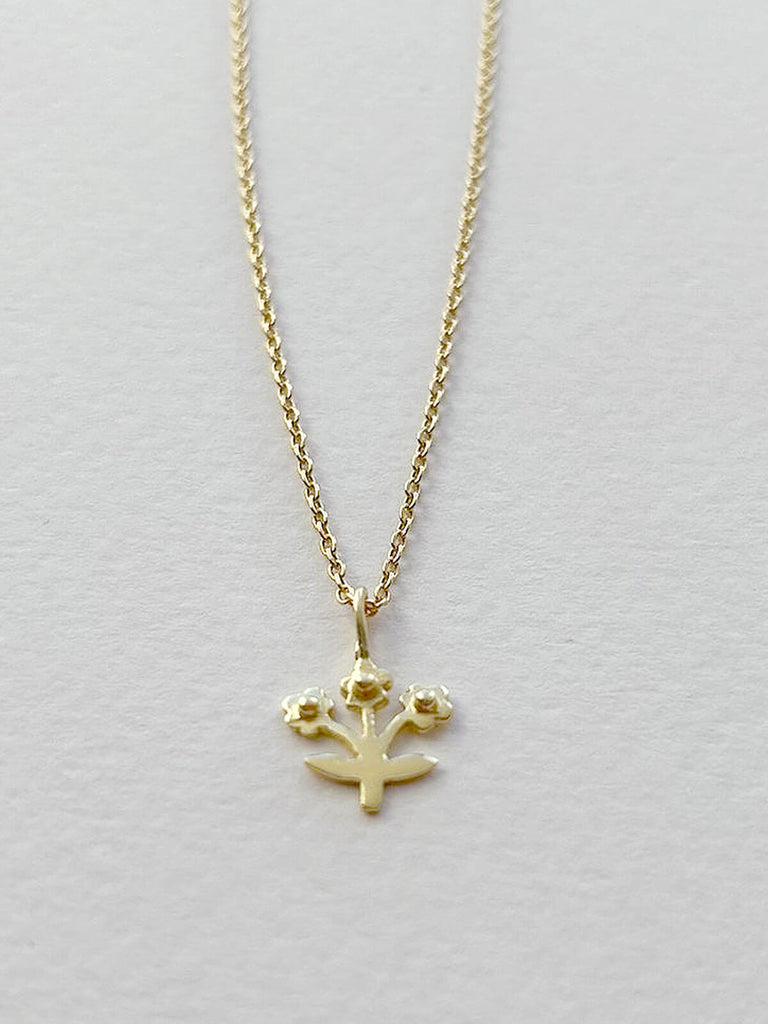 Tiny gold posie necklace featuring a delicate flower pendant on a fine gold chain