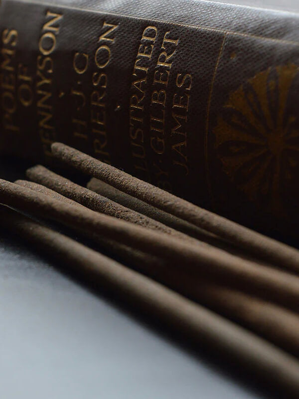 Incense sticks next to a large antique book