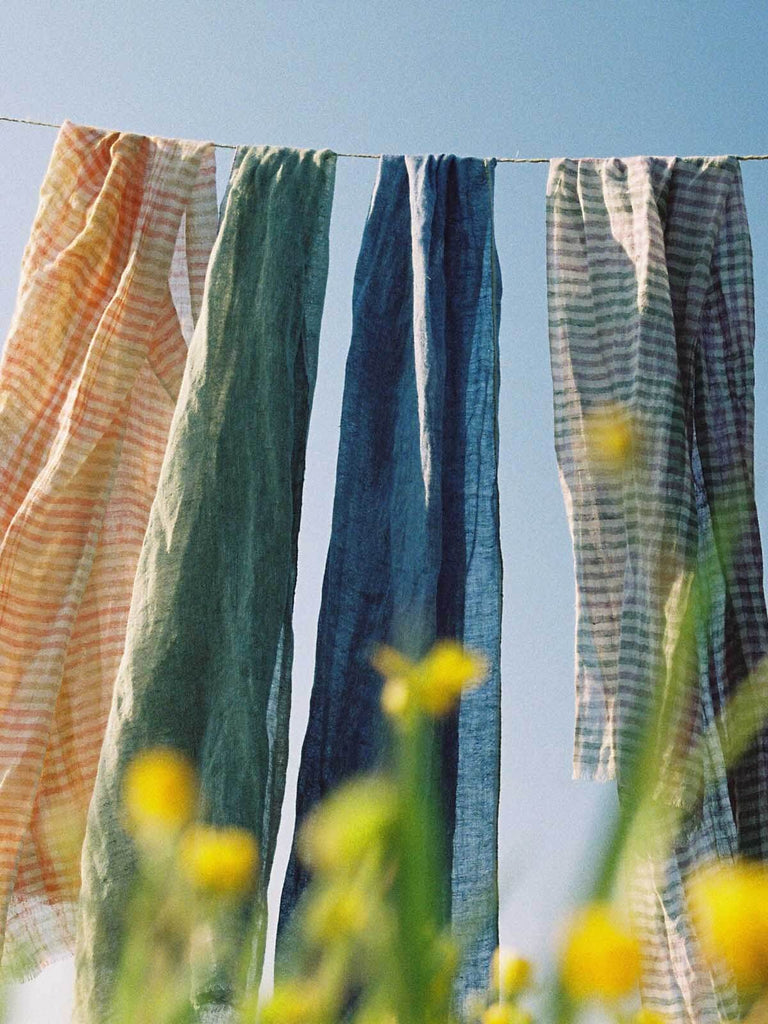 Summer Linen scarves hanging on a washing line with yellow flowers