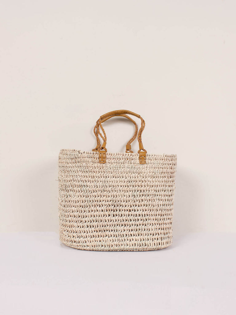 A large open weave basket with mustard colour pleated leather handles