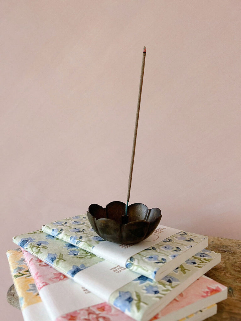 Poppy incense holder on a stack of block print notebooks