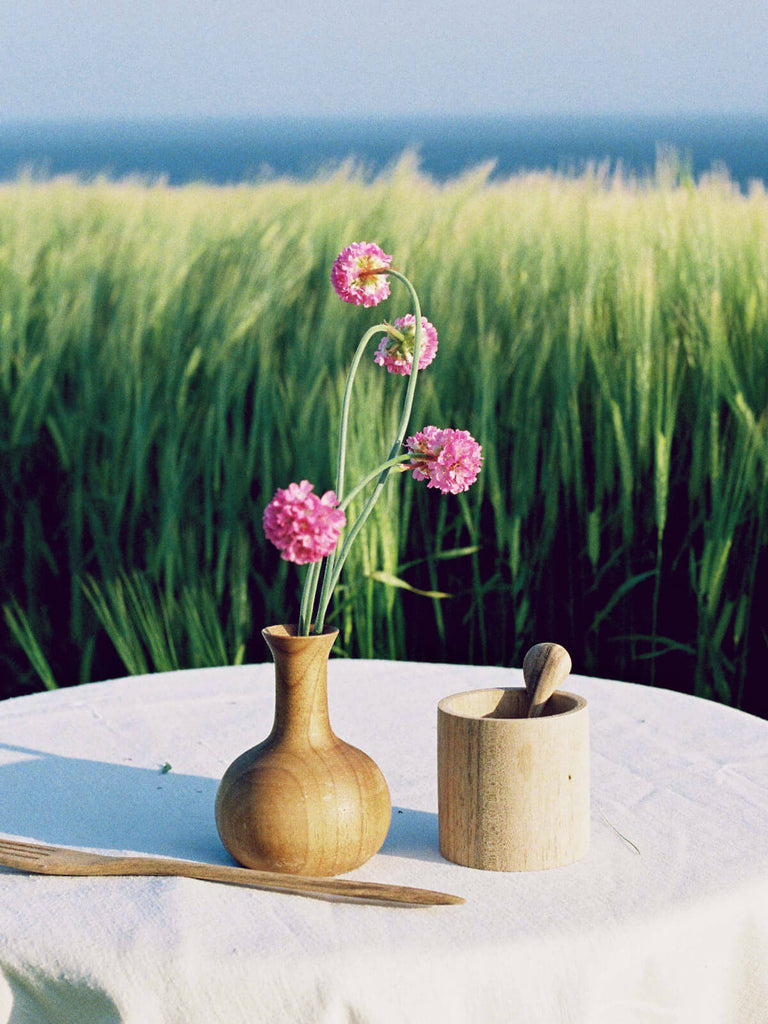 Walnut wood lidded pot and vase on an outdoor table setting
