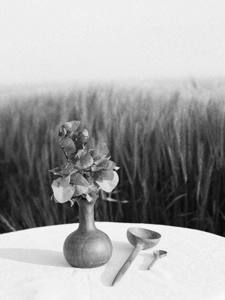 Walnut Wood Mini Vase, Joni on a small outdoor table setting next to walnut wood wooden spoons