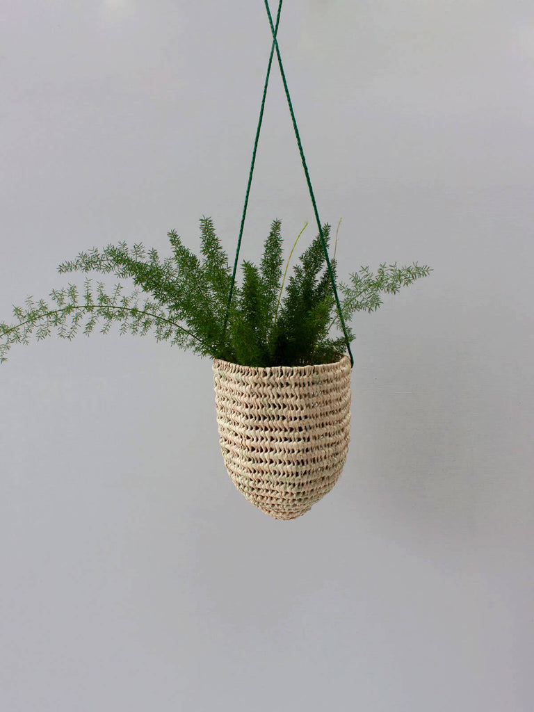 Handwoven indoor hanging basket with open weave design and finely braided green leather
