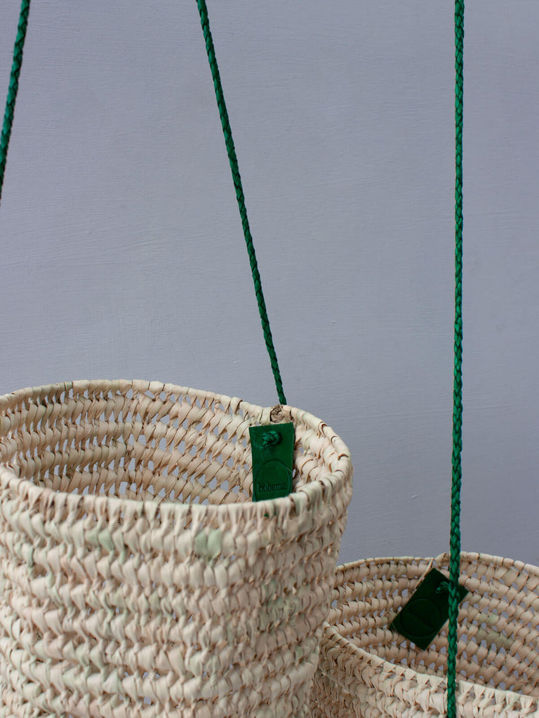 Handwoven indoor hanging baskets with open weave design and finely braided green leather