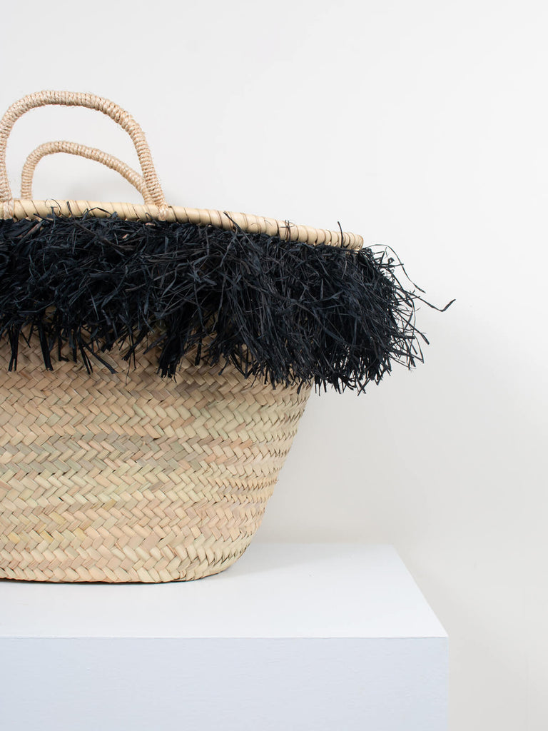 Close up of the hand dyed black raffia tassels around the top of the medium Raffia Tassel Basket