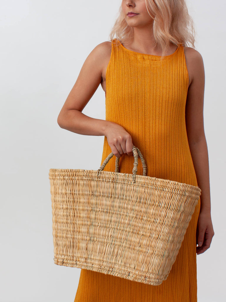 Model holding a Reed Shopper Basket by Bohemia Design