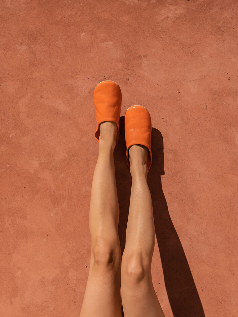 Bohemia-design-Moroccan-babouche-slippers-tangerine-leather-against-terracotta-wall