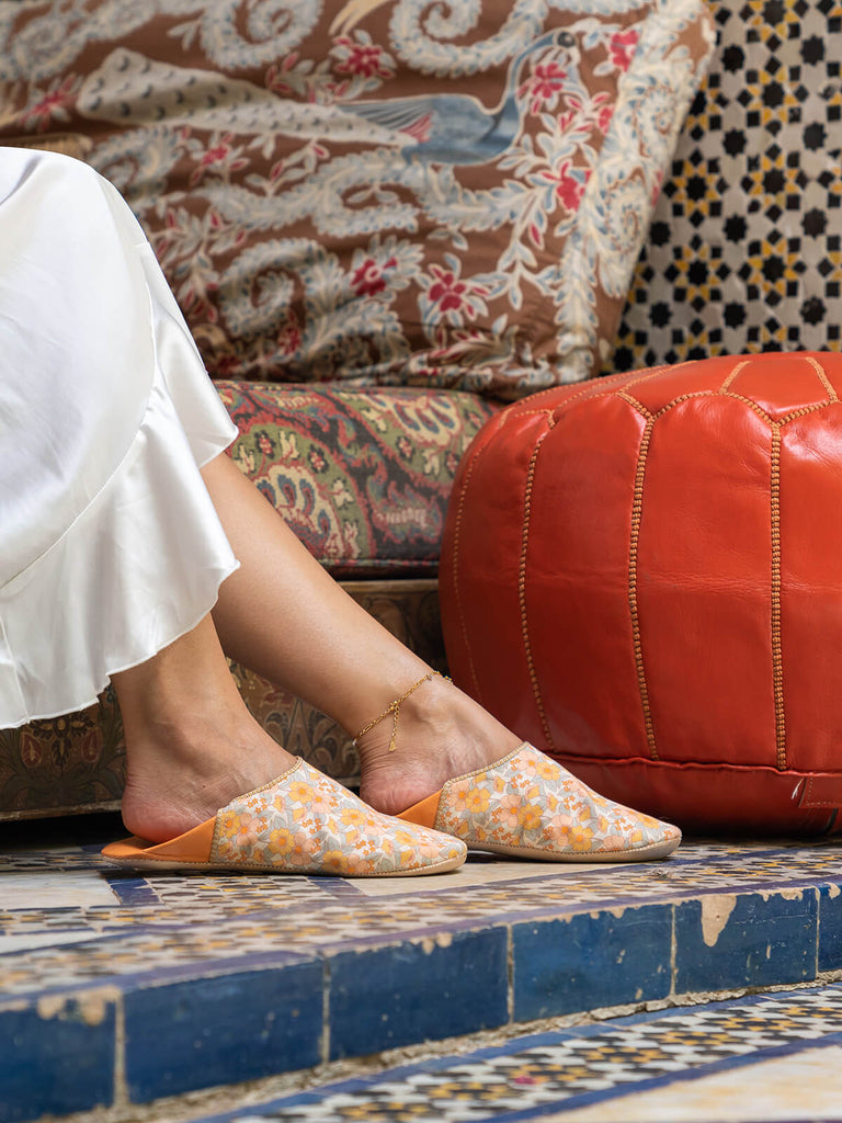 Model wearing Bohemia Design Margot babouche slippers in honey floral pattern at a Moroccan riad 