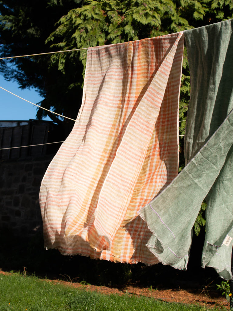 Linen scarf in mustard and orange check hanging on a washing line