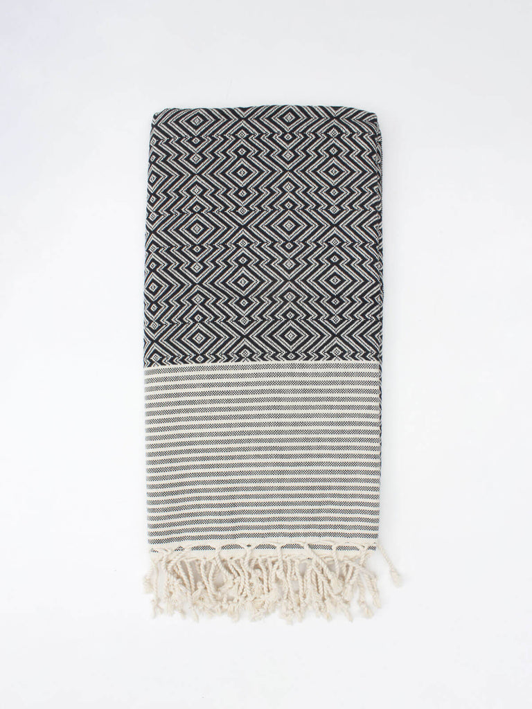 Inca Hammam Towel with a striking black and white geometric pattern and hand knotted tassels.
