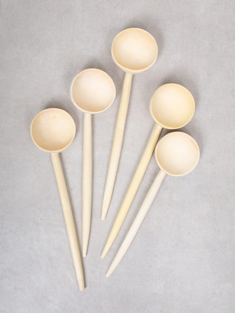 A group of large Lemon Wood Spoons on a grey background