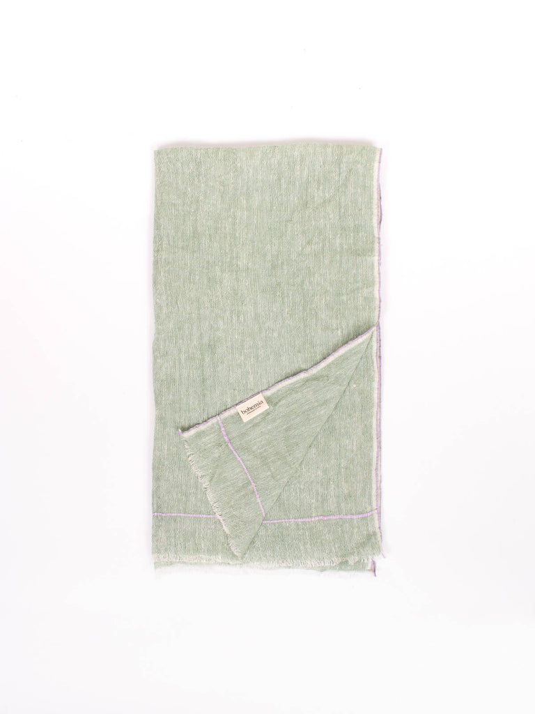 Folded linen scarf in sage with subtle lilac stitching around the edges