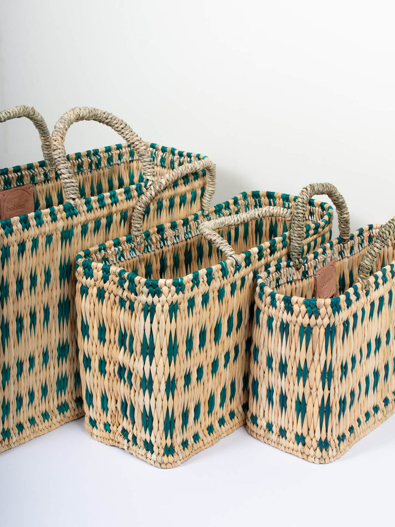 Set of three woven reed basket bags with a skillfully weaved green pattern ideal for home storage