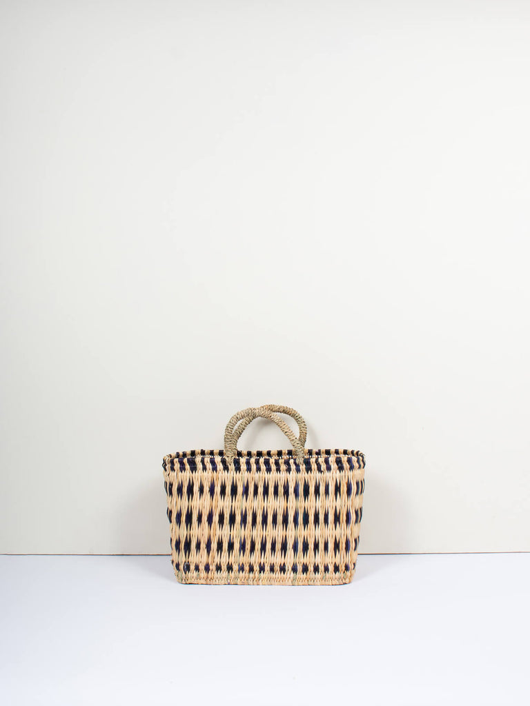 Small boxy natural woven reed tote basket bag with short handles  and skillfully weaved indigo pattern by Bohemia Design