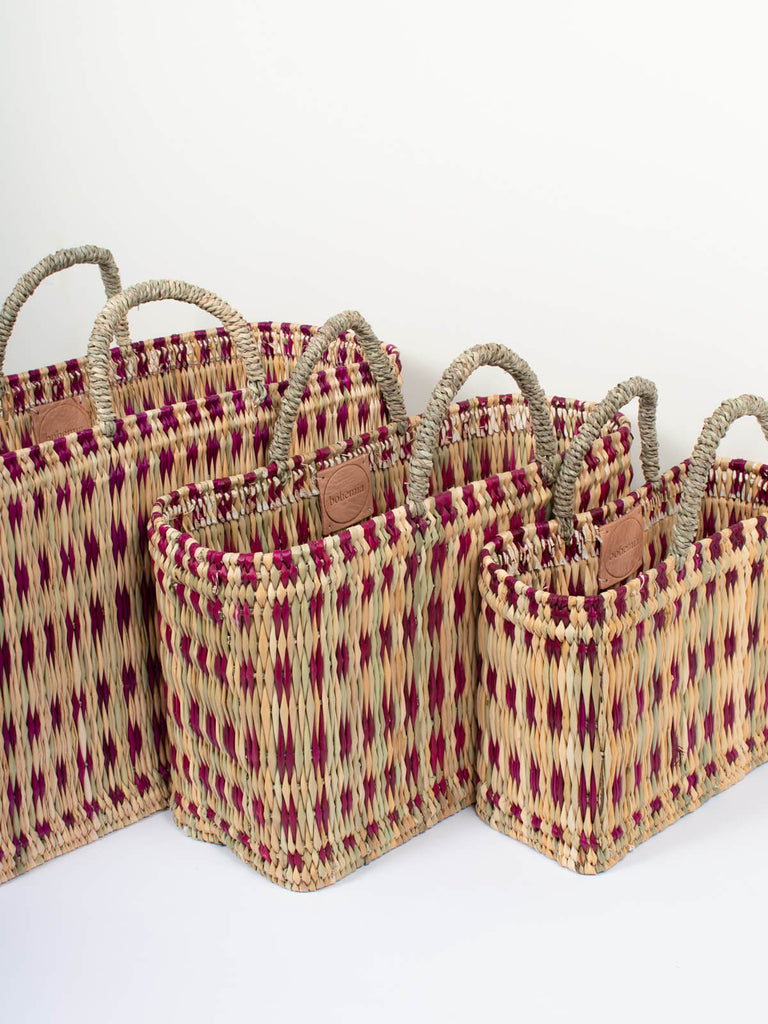Three sizes of natural woven reed market basket bags featuring a skillfully weaved violet pattern