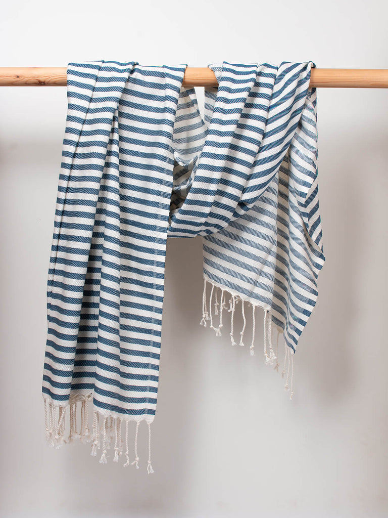 Striped Sorrento Hammam Towel in indigo stripe by Bohemia Design hanging on a wooden rod