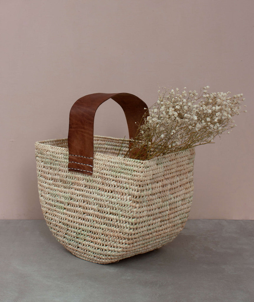 Forage basket with a tan leather handle by Bohemia design with dried flowers