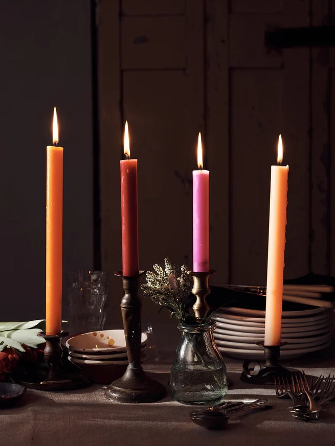 Different colours of dining candles on a dining table