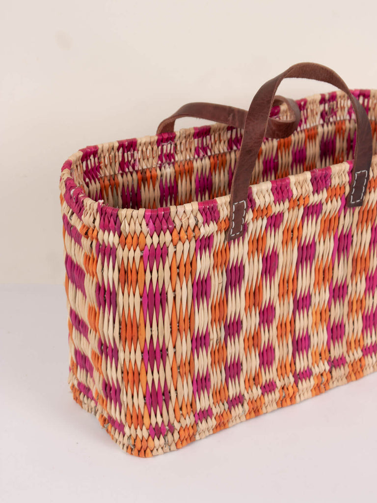 Side view showing the sturdy rectangular shape of the chequered basket bag with leather handles
