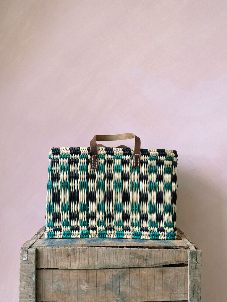 Colourful chequered green and indigo woven reed basket bag with leather handles