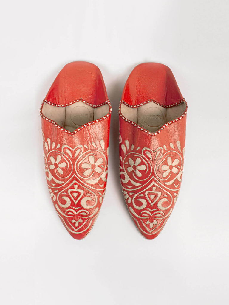 Decorative orange leather babouche slippers with intricated arabesque heart pattern.