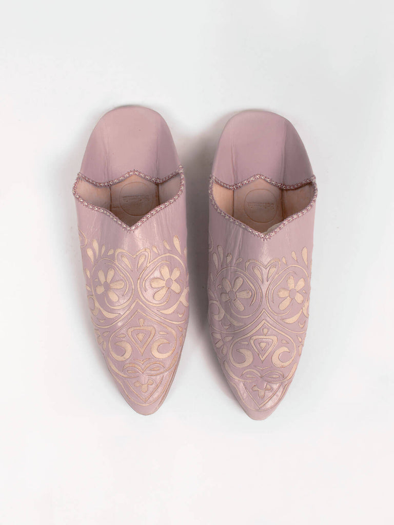 A pair of vintage pink coloured pointed leather slippers with decorative arabesque pattern.