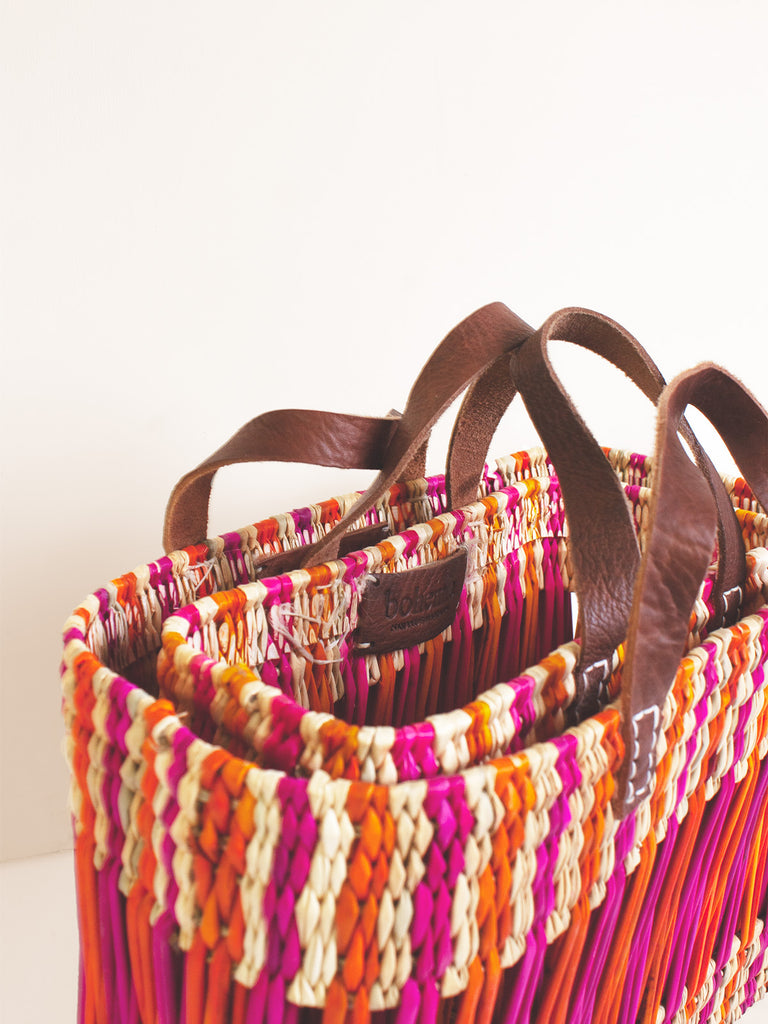 Boxy rectangular tote basket bags with leather handles and decorative pink and orange stripes
