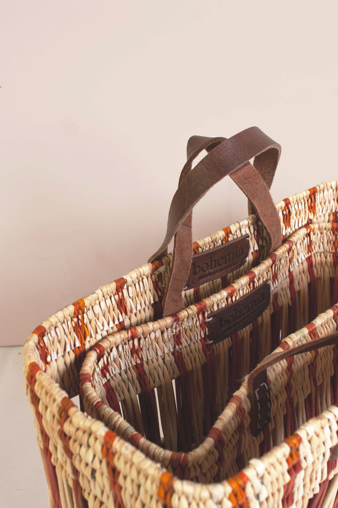 Robust rectangular shape baskets handwoven from reeds with natural leather handles.