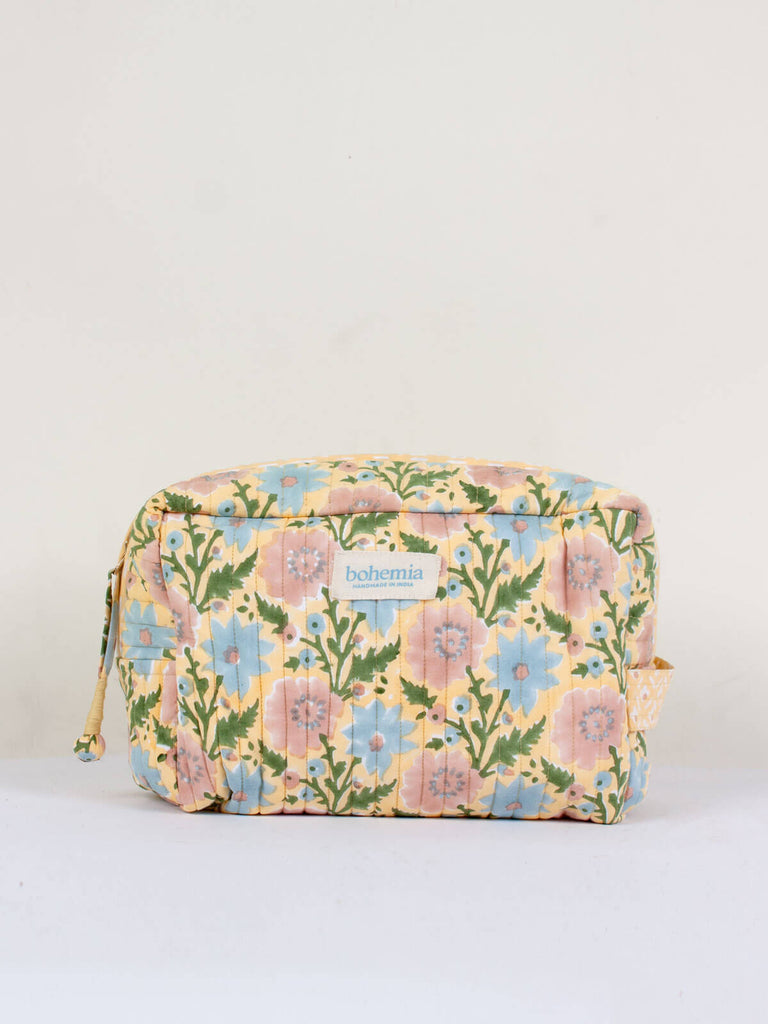 Large hand block print, cotton quilted wash bags in a creamy buttermilk yellow, blue and pink floral design