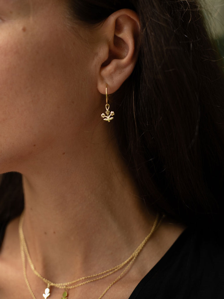 Model wearing delicate gold posie hoop earrings by Bohemia Design