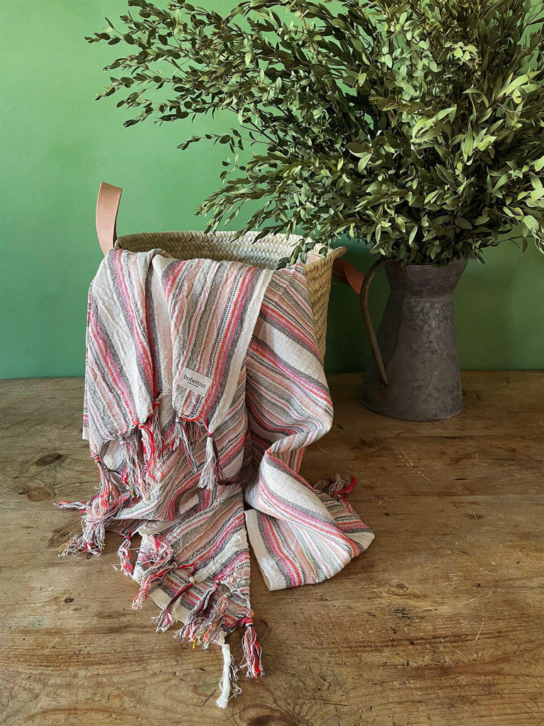 Turkish cotton hammam towel with dusky pink and terracotta stripes in a natural basket