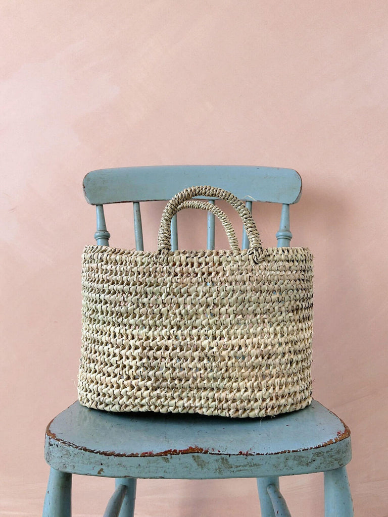Large oval shaped natural woven straw basket with open weave design