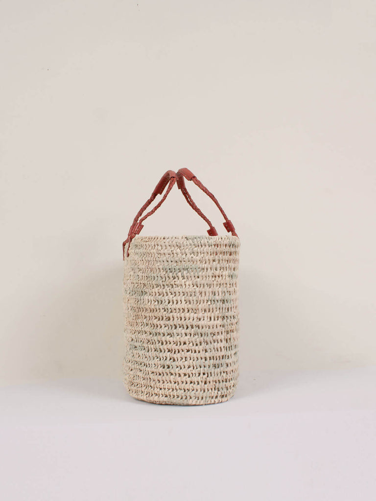 View showing the oval shape of the natural woven basket with terracotta pleated leather handles