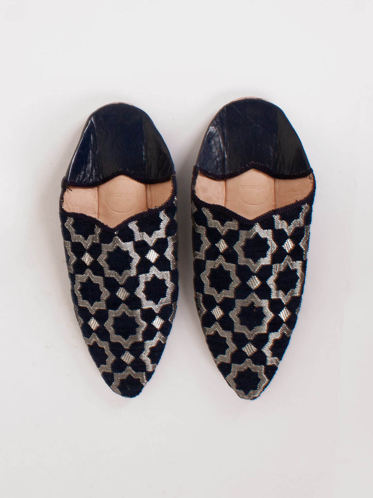A pair of Moroccan Star Brocade Pointed Babouche Slippers in Indigo on a light background
