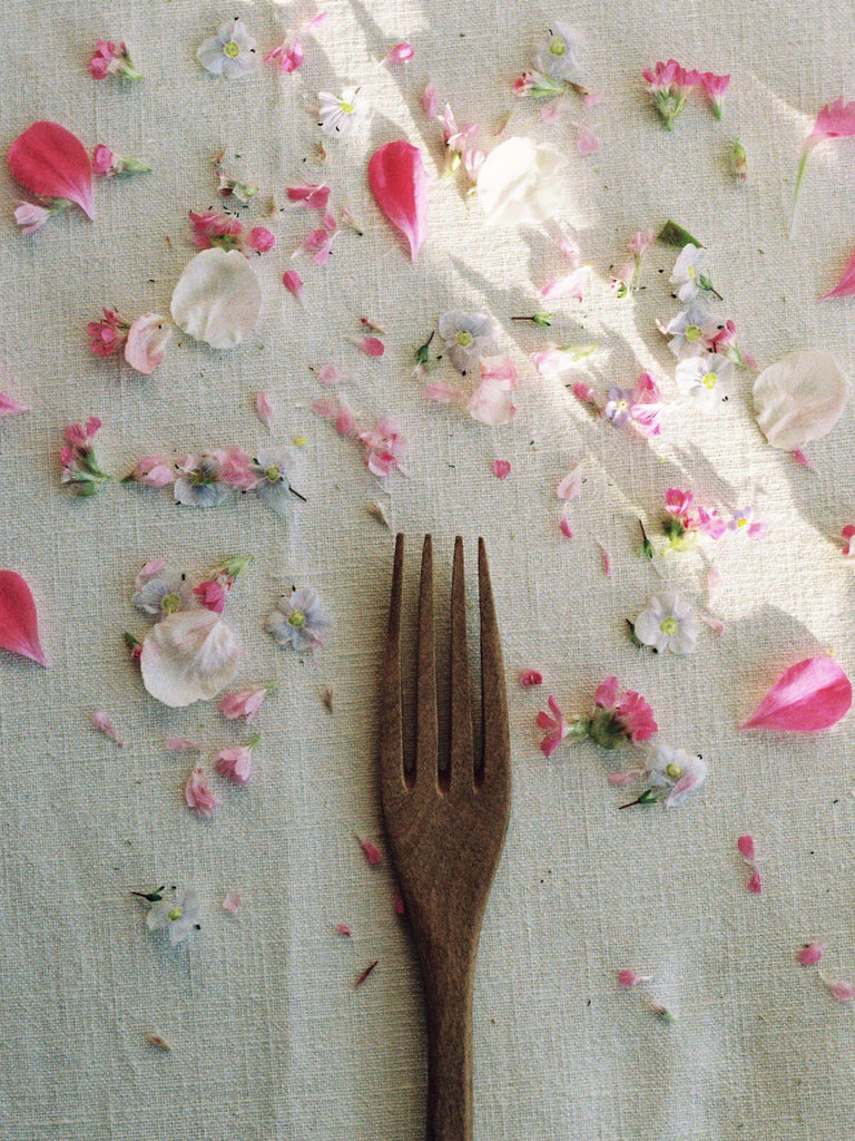 Walnut Wood Fork on a linen tablecloth surrounded by pink flower petals