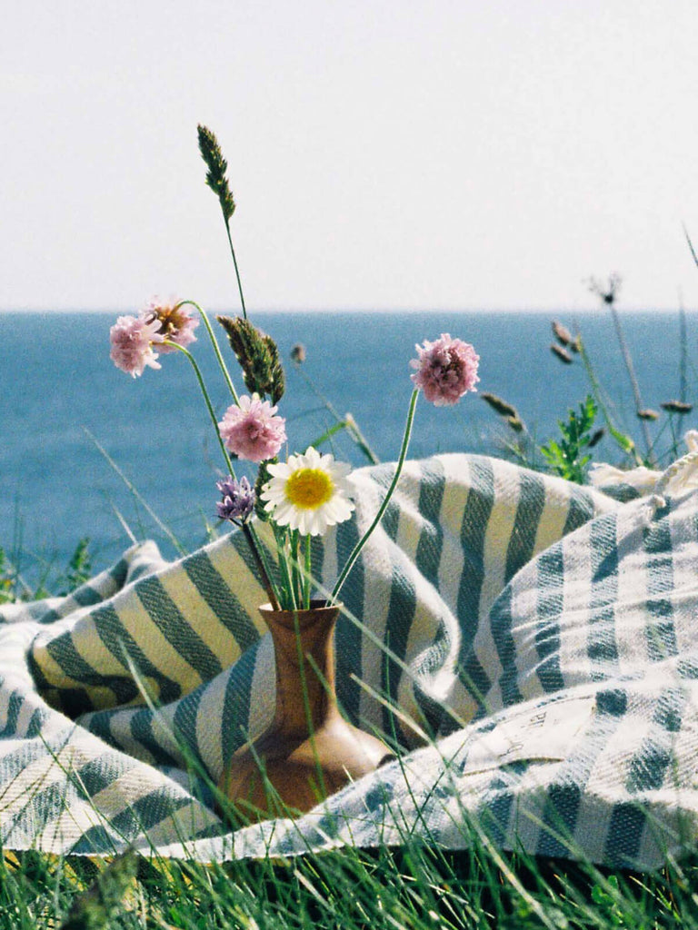 Walnut Wood Mini Vase, Joni filled with wild flowers on a striped hammam towel by the sea