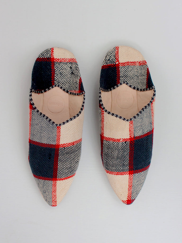 A pair of handmade leather and fabric Moroccan boujad pointed babouche slippers in a navy and red check print by Bohemia Design