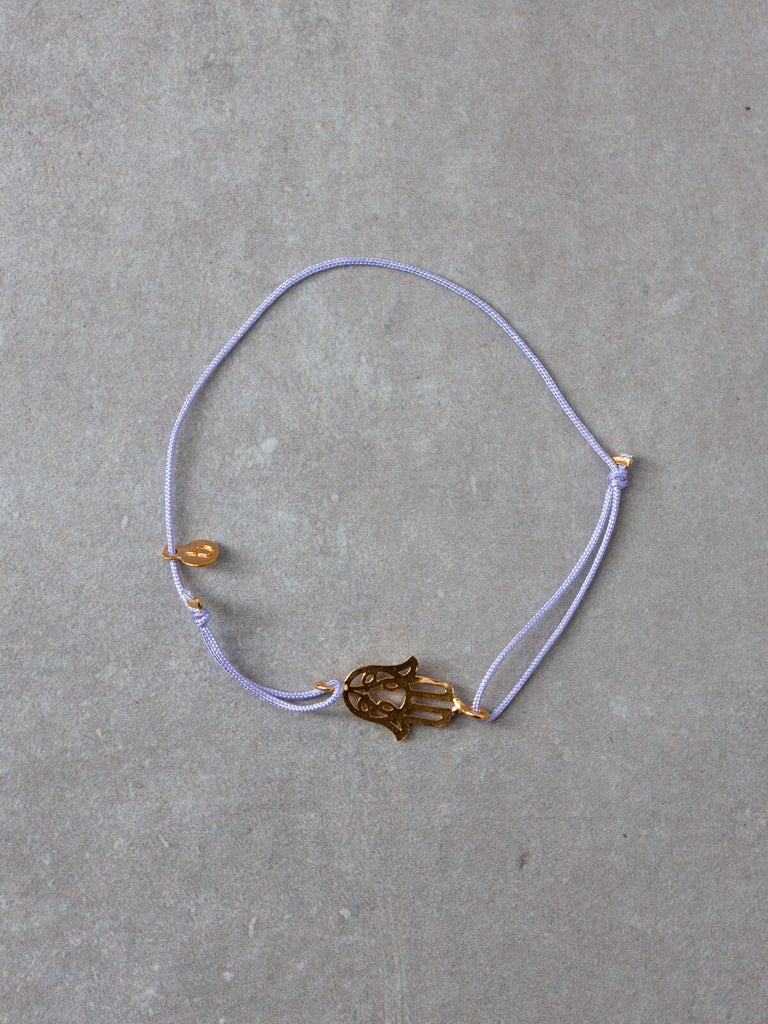 An 18ct gold plated hamsa hand bracelet with an adjustable lilac silk thread by Bohemia Design