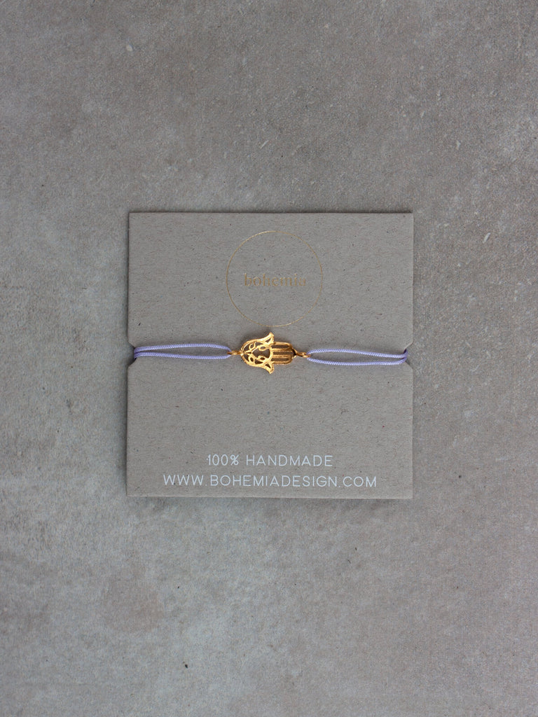 An 18ct gold plated hamsa hand bracelet with an lilac silk thread by Bohemia Design