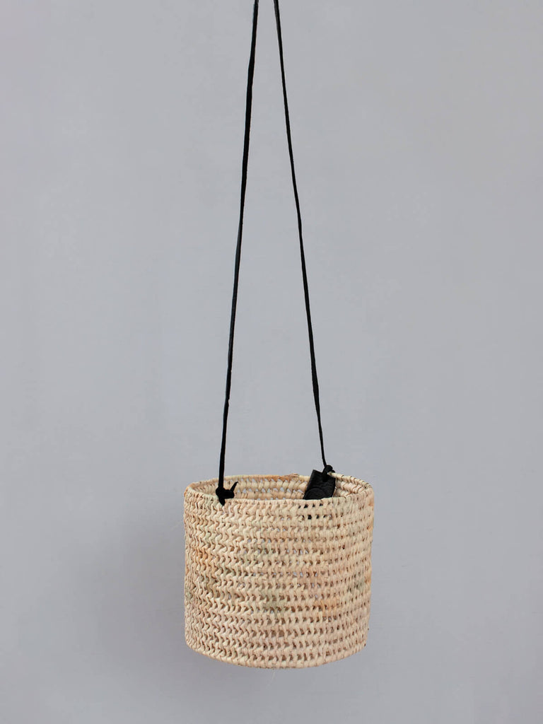 Elegant woven indoor hanging planter with open weave design and black leather thong