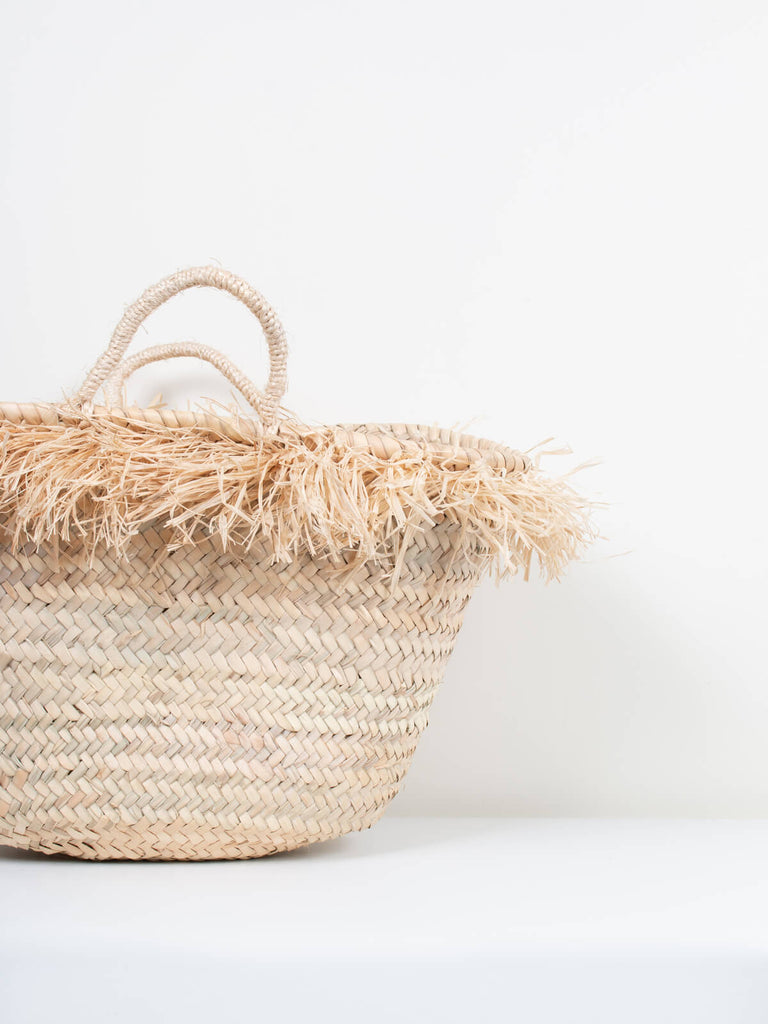 Close up of the natural tassels on the small handwoven Raffia Tassel Basket