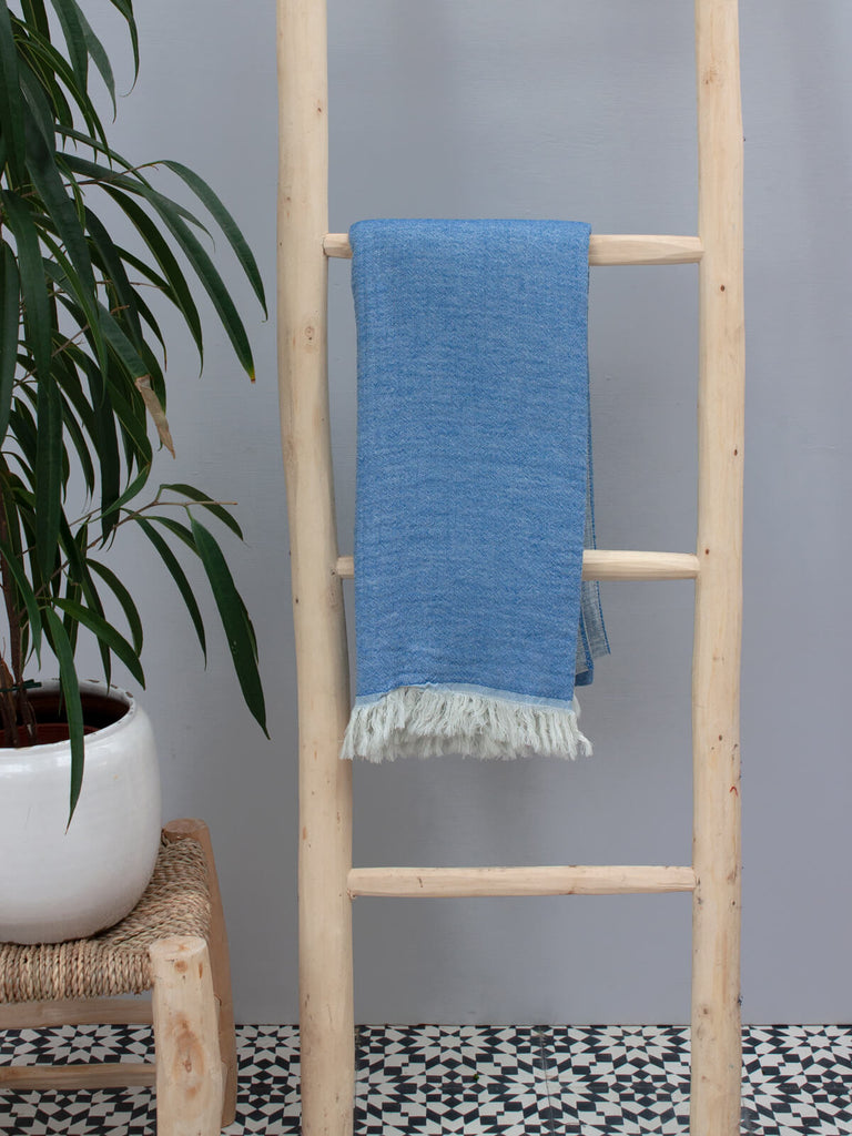 Samos Hammam Towel in serene blue hues of Sea and Sky displayed on a wooden ladder | Bohemia Design