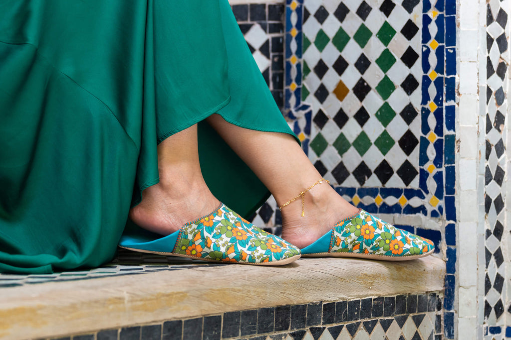 Model wearing Bohemia Design Margot babouche slippers in aqua floral pattern at a Moroccan riad 